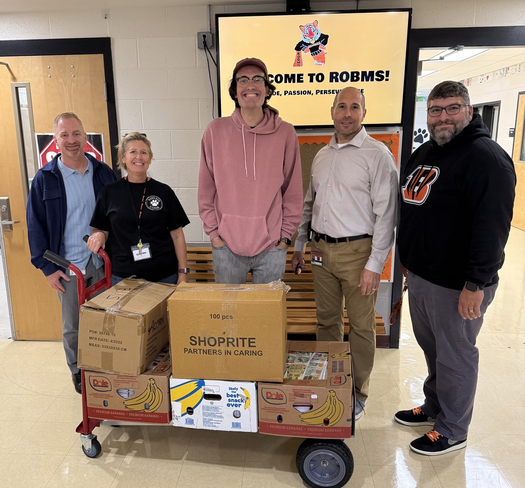 Image of the school district personnel and WOBM representative with the donations on a cart.  