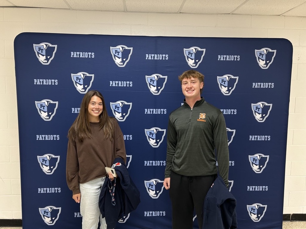 Image of Emma and Nick posing in front of a banner. 