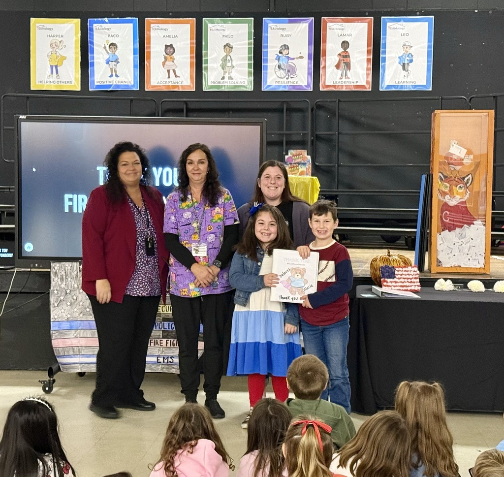 Image of the Principal, teacher, and two students presenting handmade cards to the school nurse.
