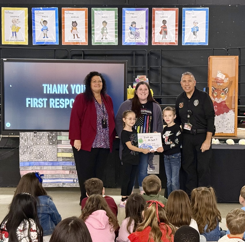 Image of the Principal, teacher, and two students presenting handmade cards to the security officer.