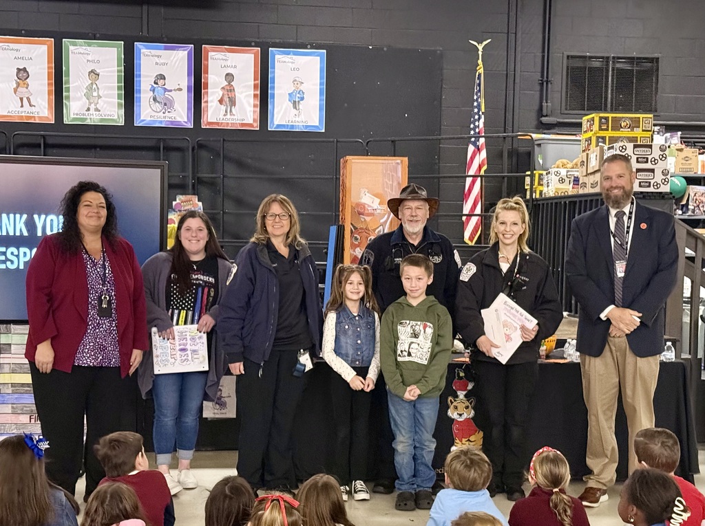 Image of the Superintendent, Principal, three EMS representative, and two students presenting the handmade cards and check.