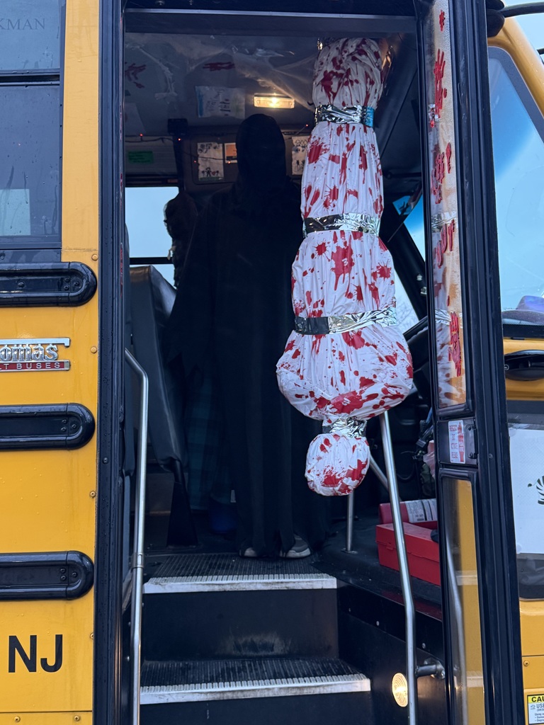 Image of the entrance to the bus where the driver was dressed up standing next to decorations.