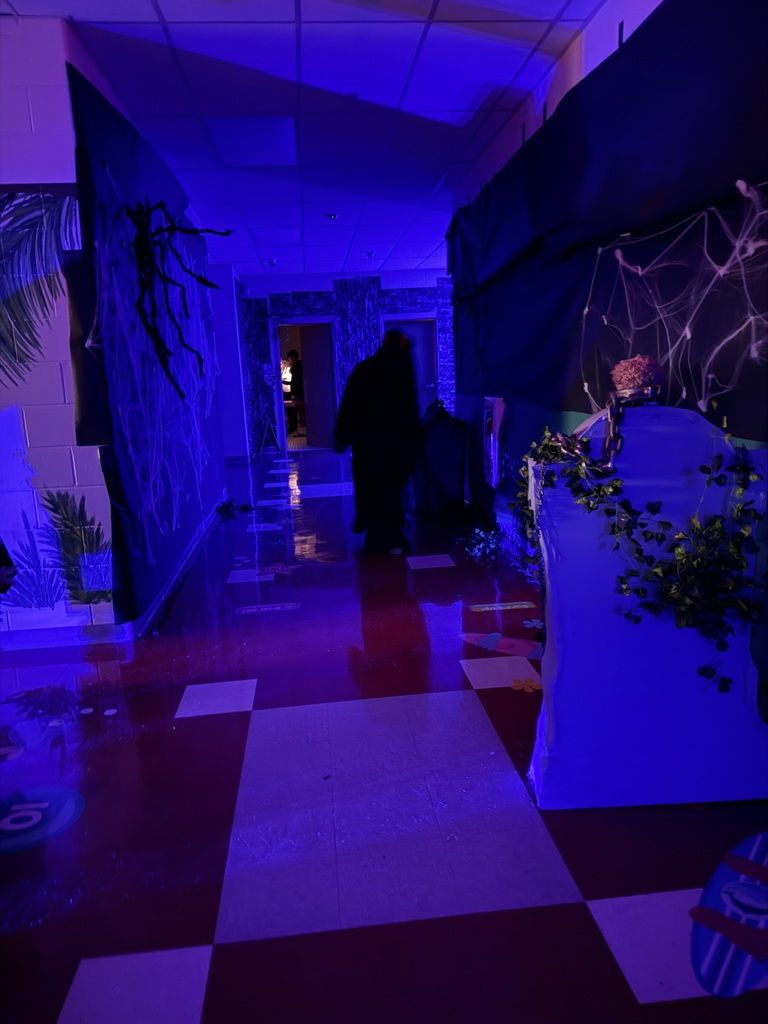 Image of the decorated hallway and staff member dressed up for the spooky hallway tour. 