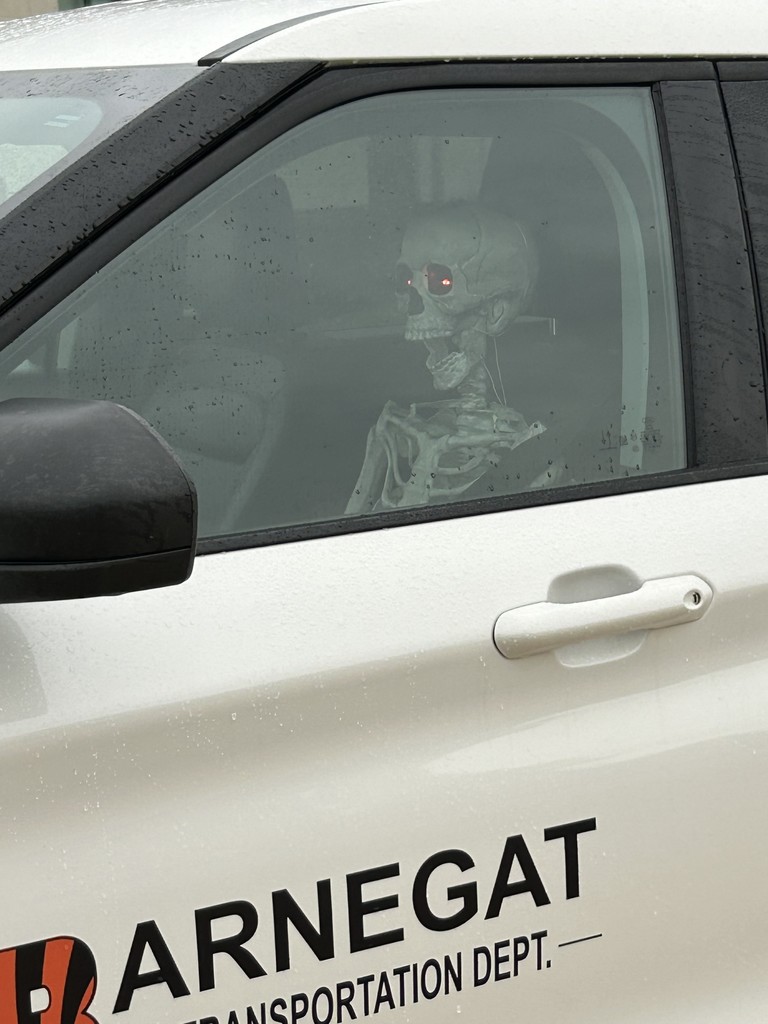 Image of a skeleton sitting in the passenger seat of the Transportation Department vehicle. 