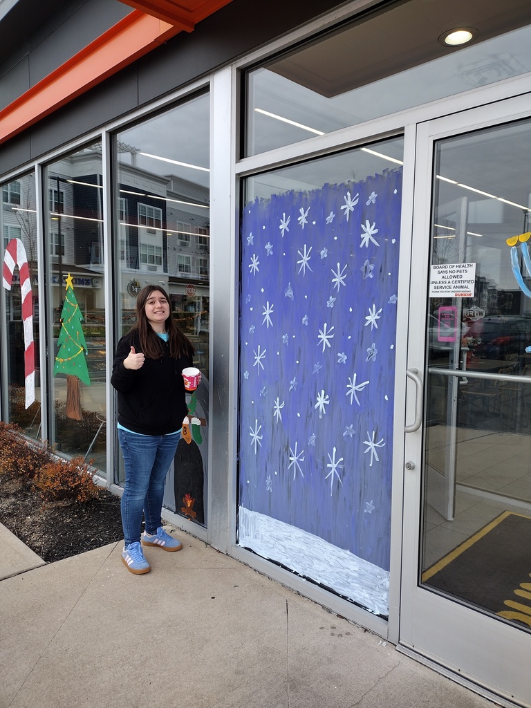 Image of a student standing next to her completed snowfall scene. 