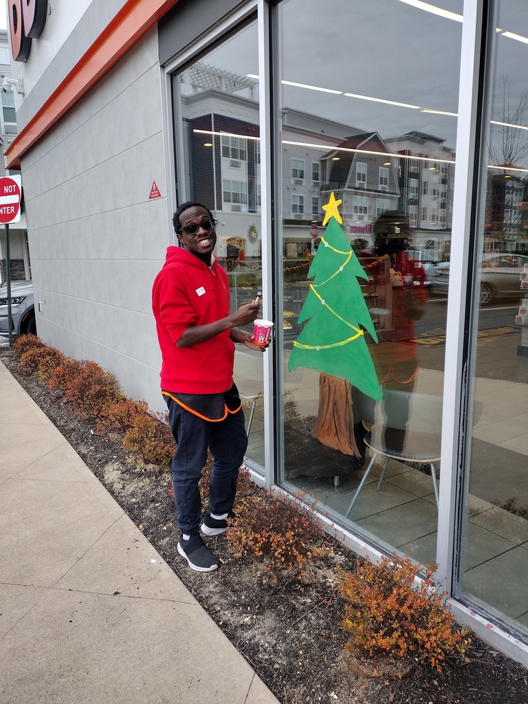 Image of a student painting a Christmas tree. 