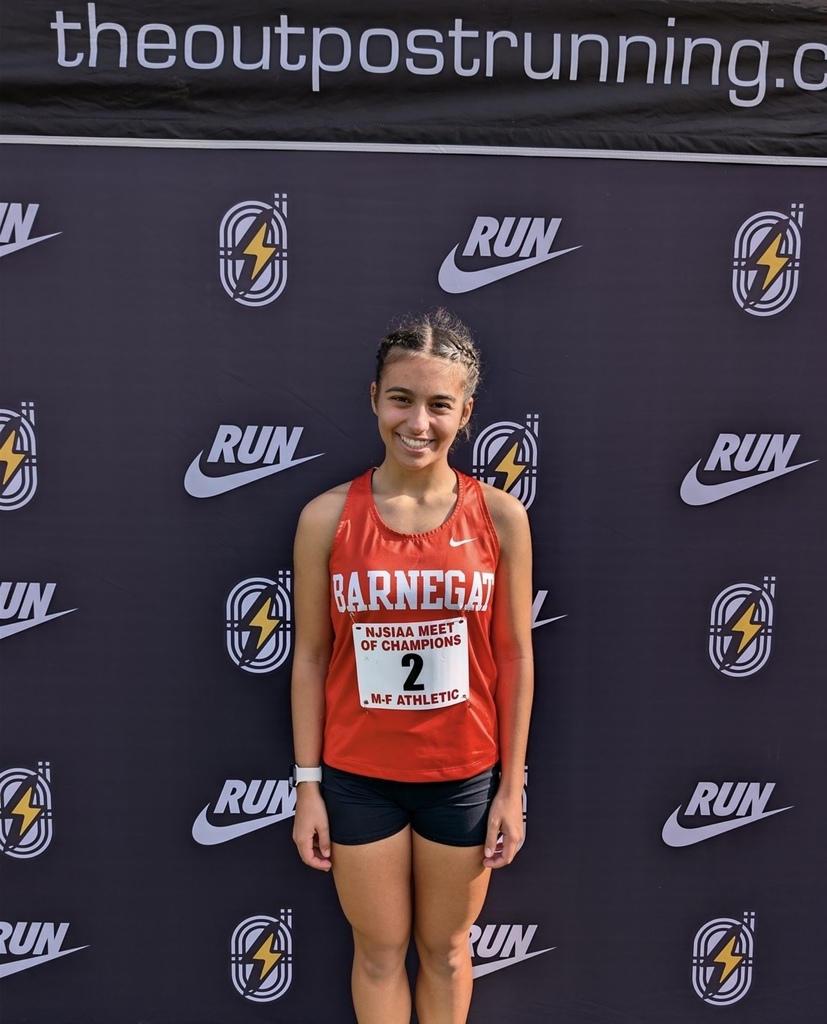 Image of Angelina posing in front of a background that says RUN with a swoosh symbol. 