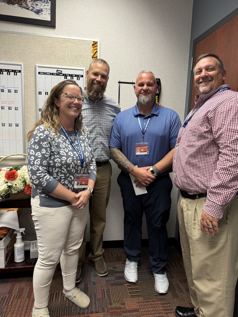 Image of Jared Burke posing with the Superintendent, Principal, and co-Vice Principal. 