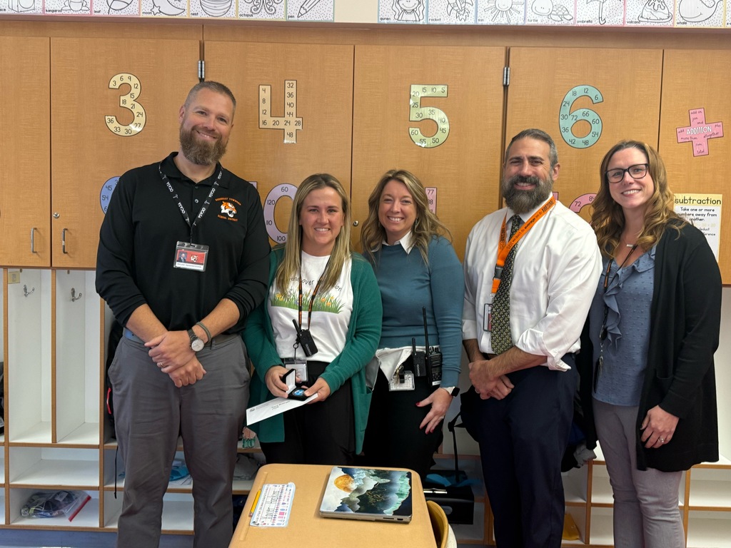 Image of Kerry posing with the Superintendent, district and building administrators. 