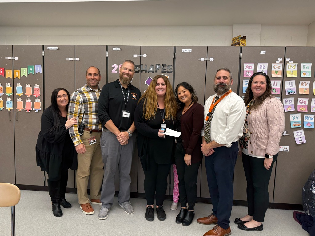 Image of Maria posing with the Superintendent, district and building administrators. 