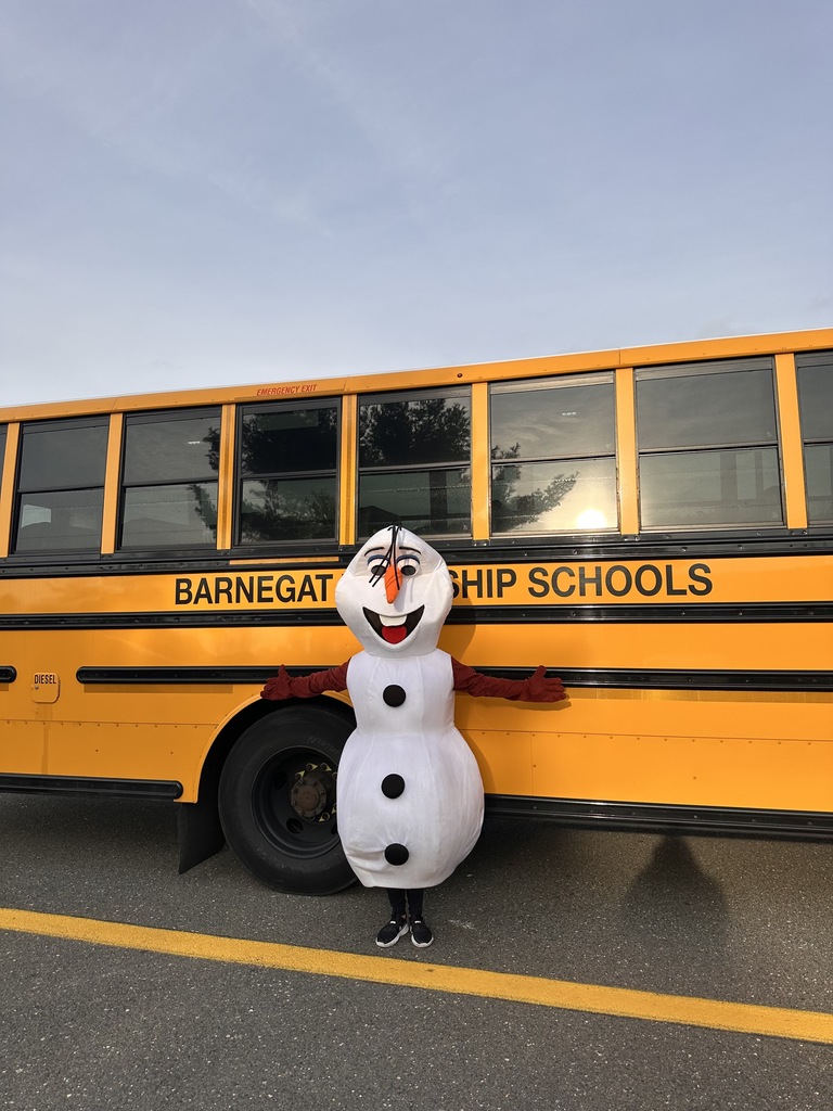 Image of Olaf posing by a school bus. 