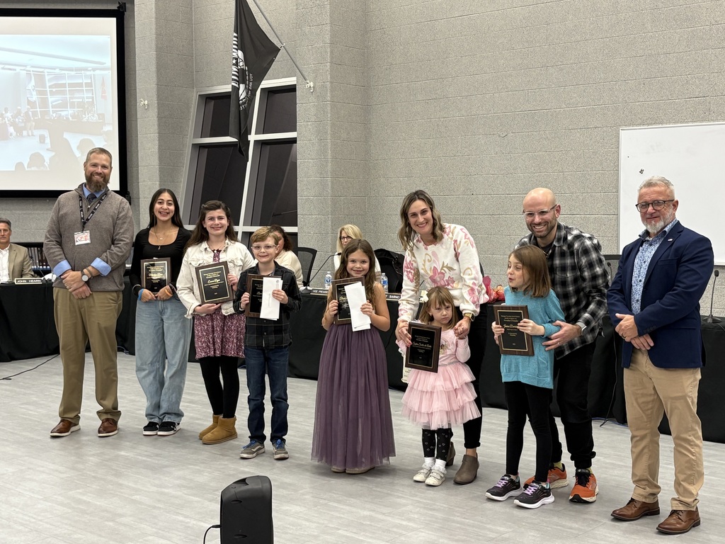 Image of the November UPstander posing with their awards with the Superintendent and Board President.