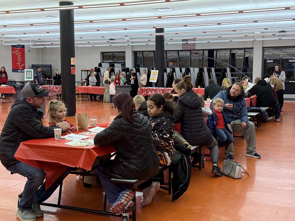 Image of families sitting at a table coloring holiday themed pictures.