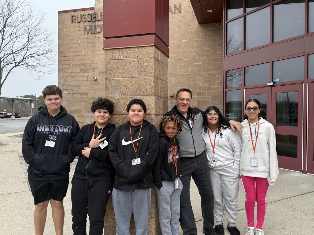 Image of Mrs. Capasso's students posing with Mr. Rob outside the building. 