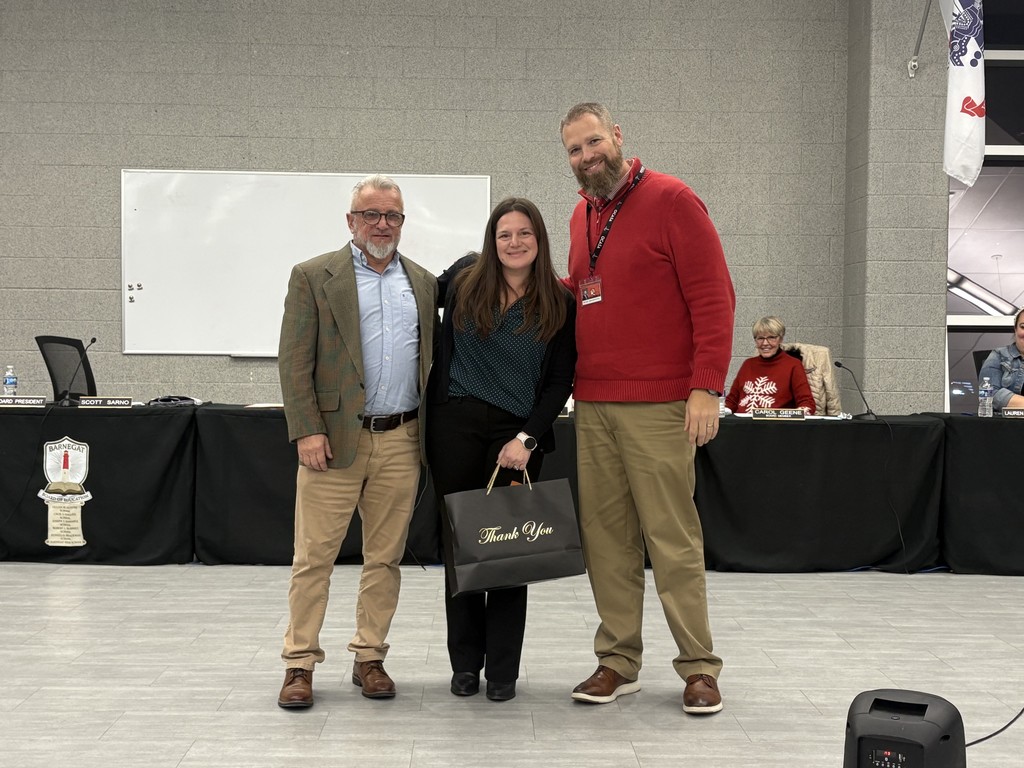 Image of the Superintendent and Board President posing with Kelly. 