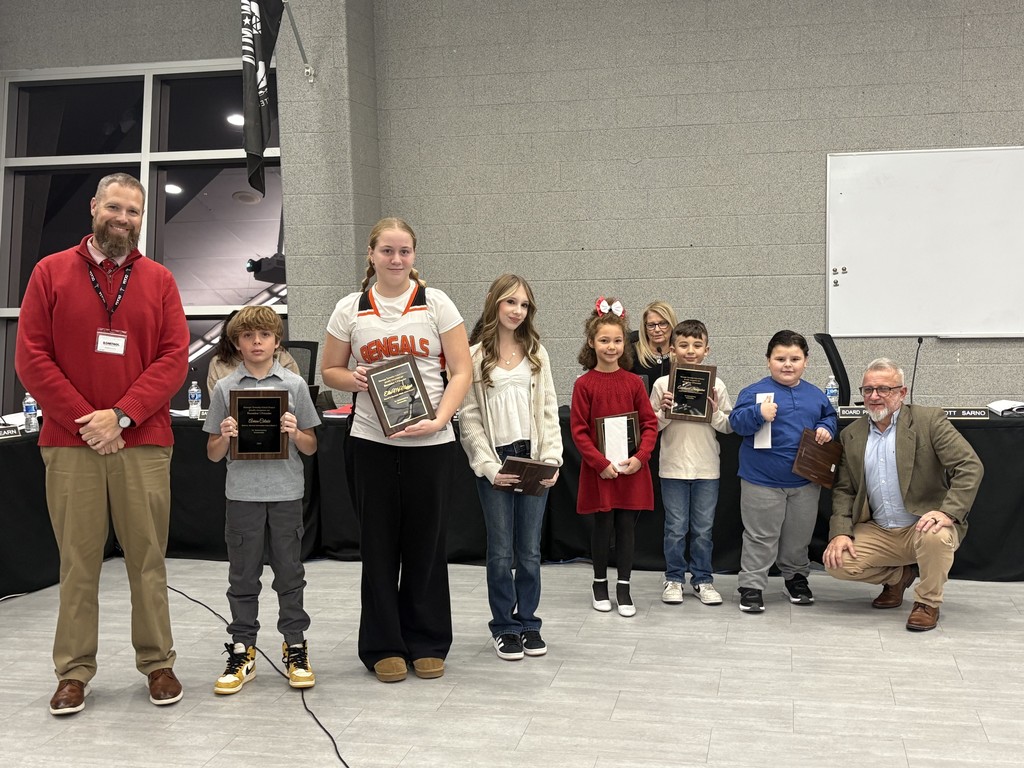 Image of the Superintendent and Board President posing with the UPstander award recipients. 