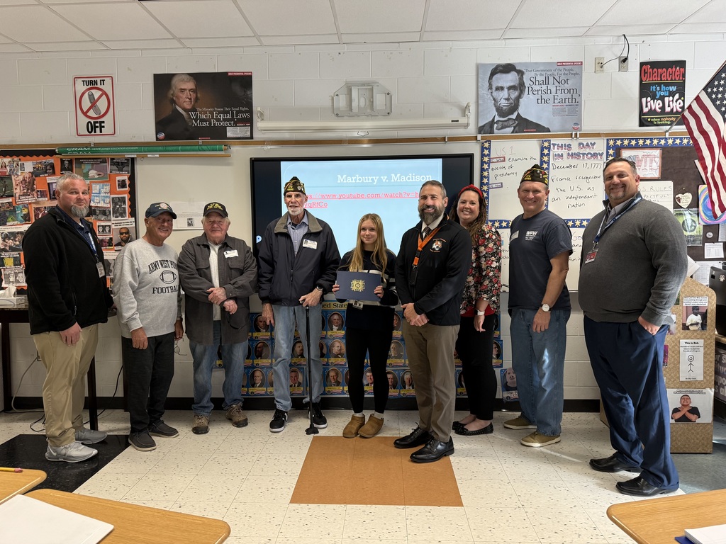 Image of the second place winner posing with District and building administrators along with members of the VFW. 