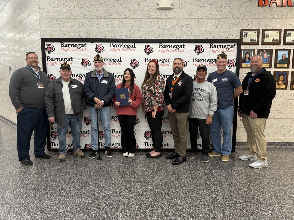 Image of the third place winner posing with District and building administrators along with members of the VFW. 