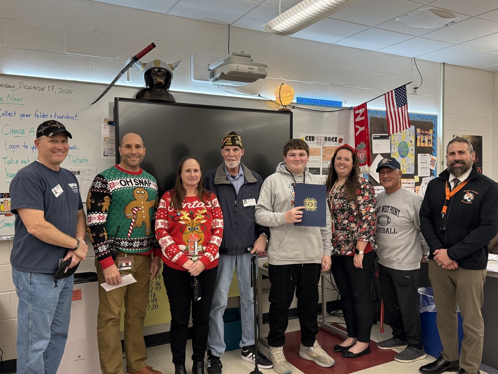 Image of the first place winner posing with District and building administrators along with members of the VFW. 