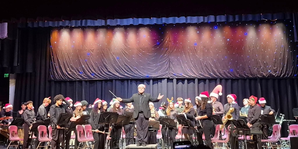 Image of the band standing after their performance with the director on stage. 