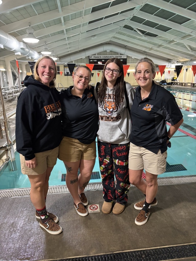 Image of Emily posing with the three coaches. 