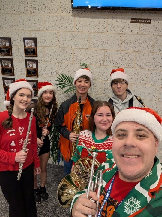 Image of Mr. McGrath and members of the Tri-M Music Honor Society taking a selfie holding their instruments. 