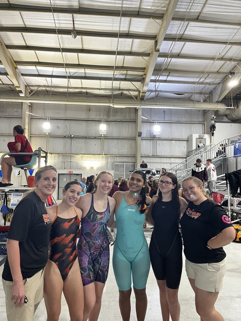 Image of the four girls posing in between the two coaches. 