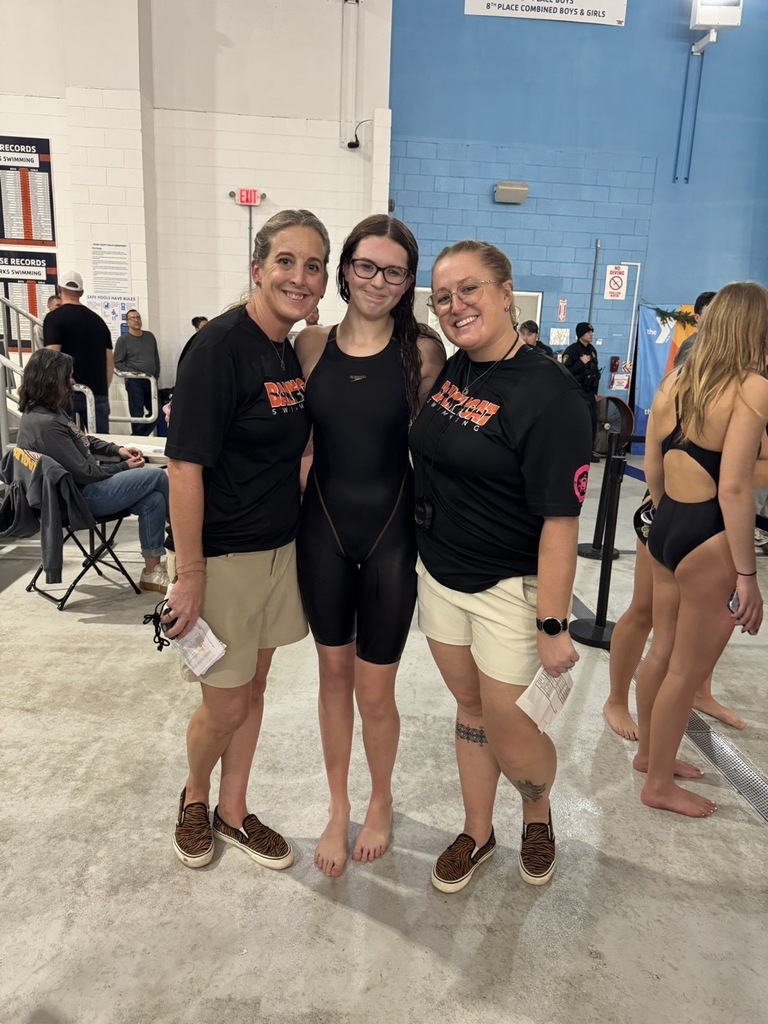 Image of Emily posing with the two coaches. 