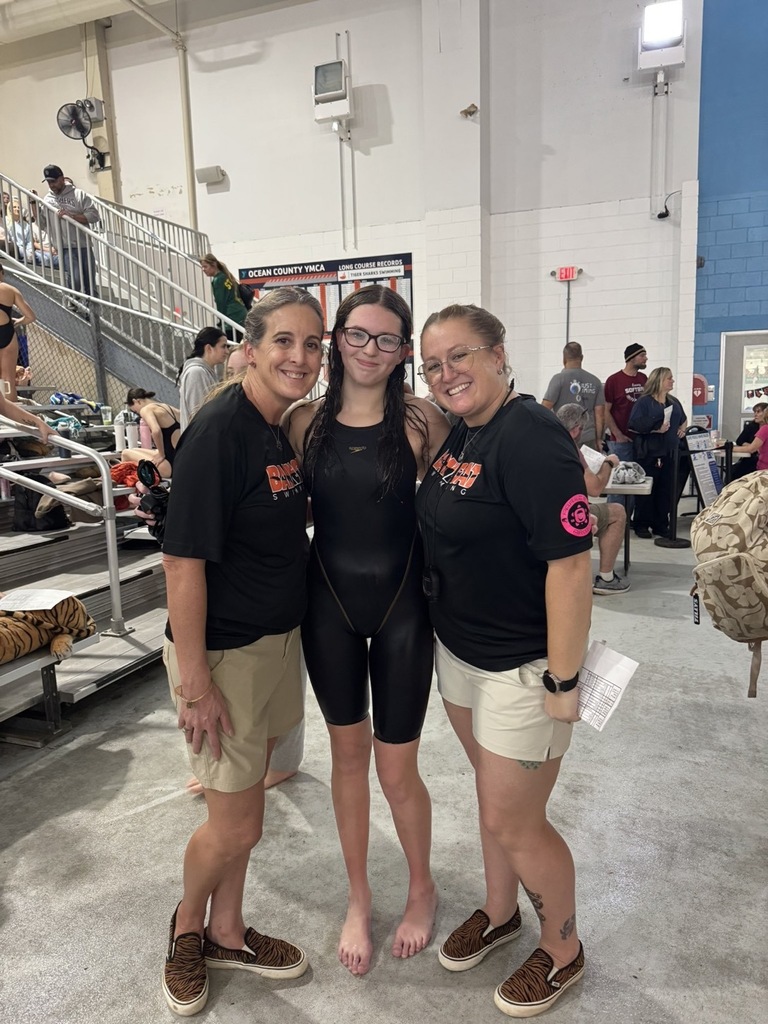 Image of Emily posing with the two coaches. 