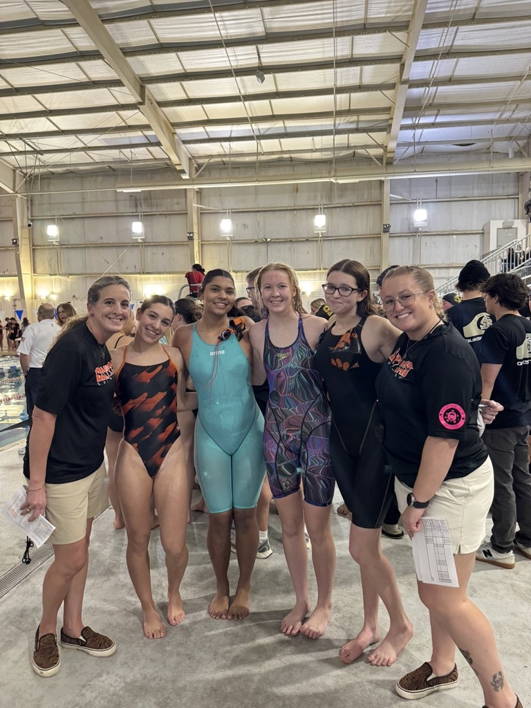 Image of the four girls posing in between the two coaches. 