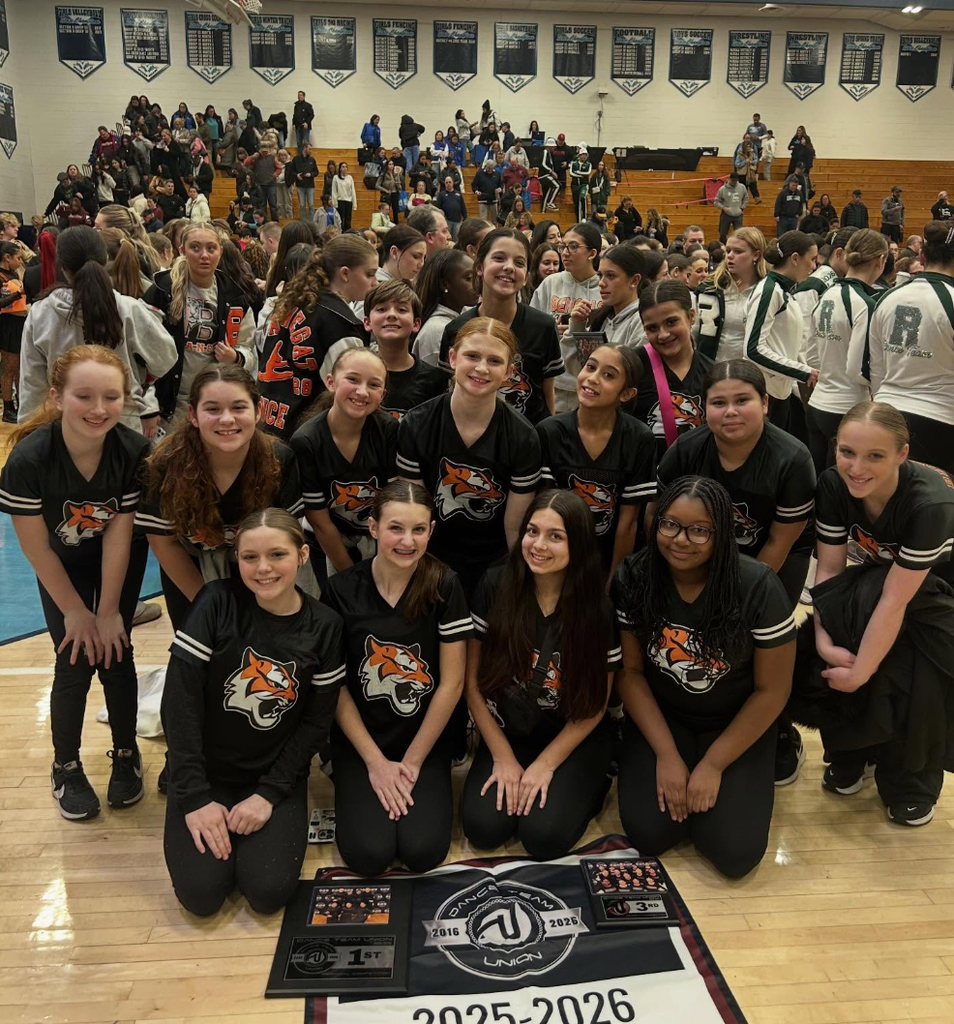 Image of the Brackman Dance Team posing with their banners and plaques. 