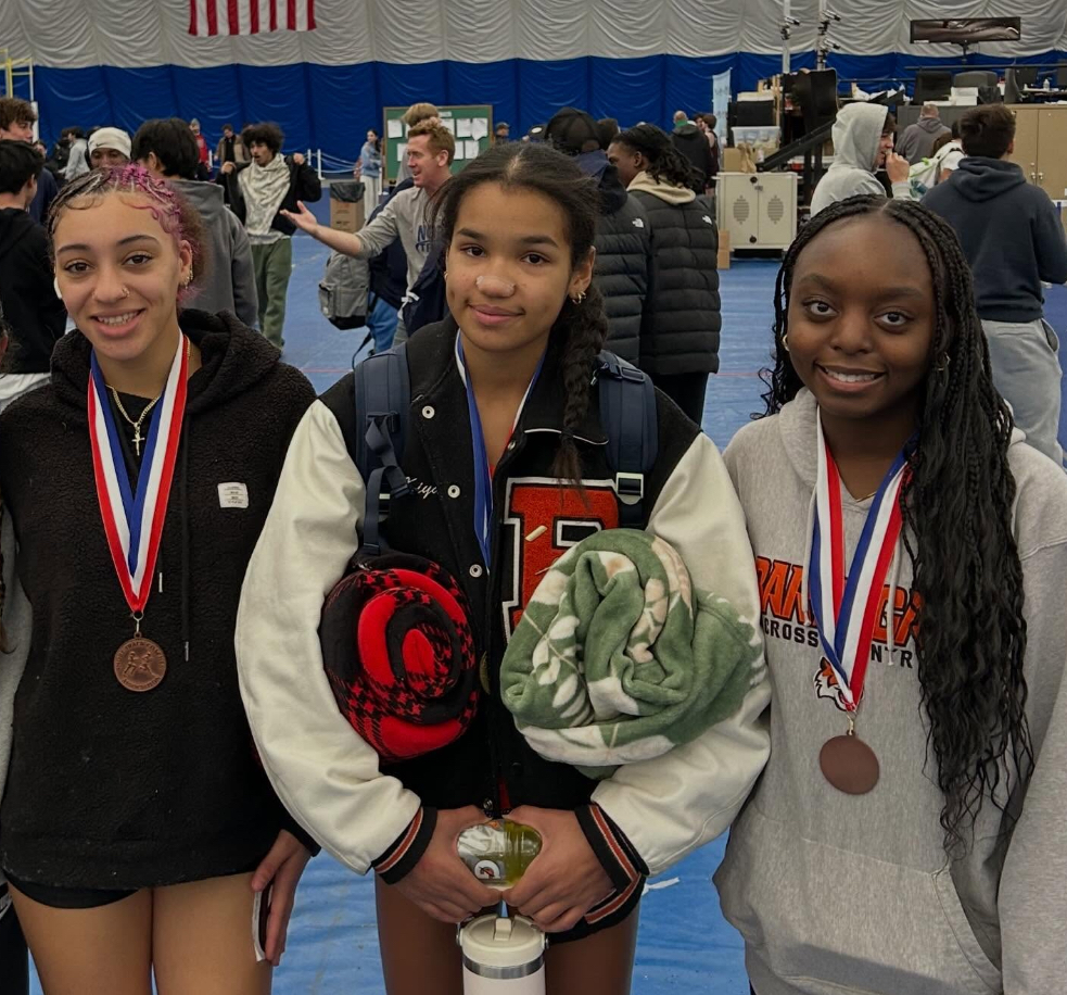 Image of Kiyana wearing her medal standing between two friends who are also wearing medals. 