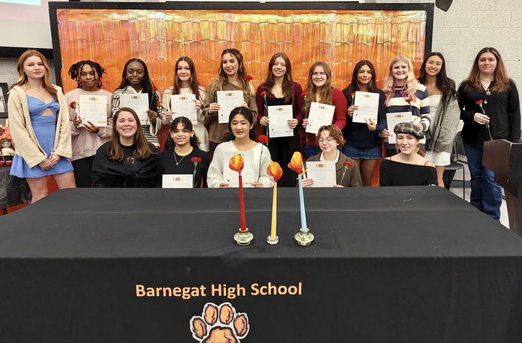 Image of the new inductees of the BHS National Art Honor Society holding certificates and flowers. 