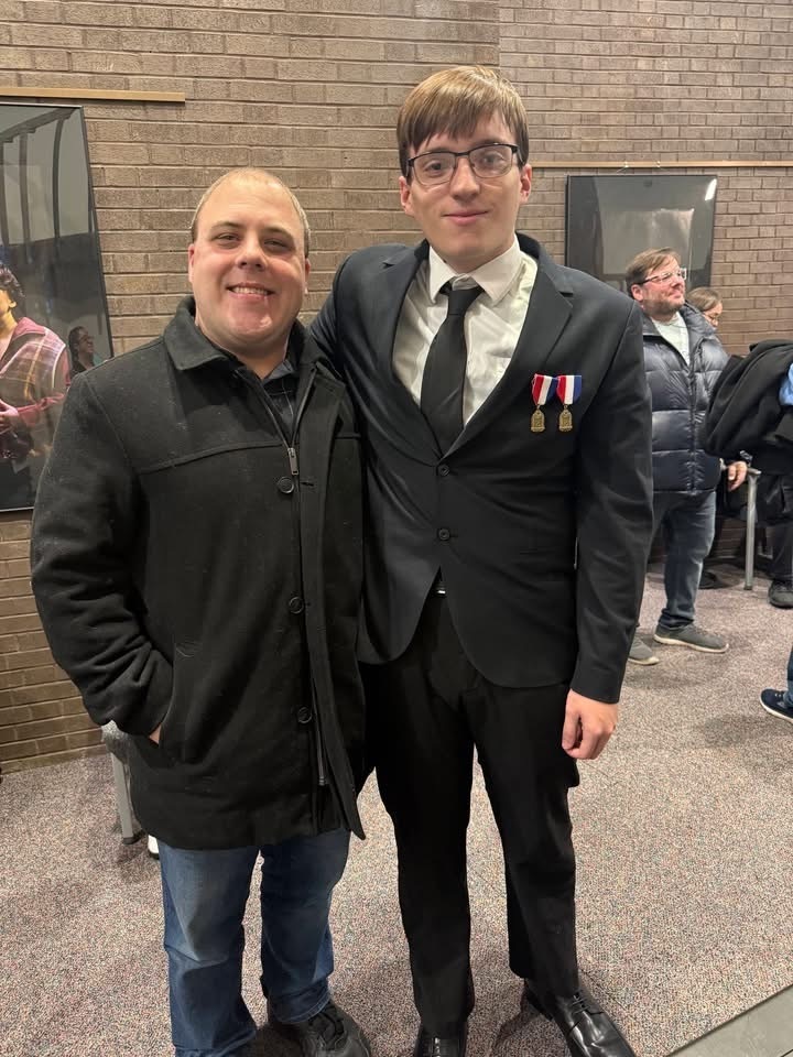 Image of Liam posing with Mr. McGrath, BHS band director. 