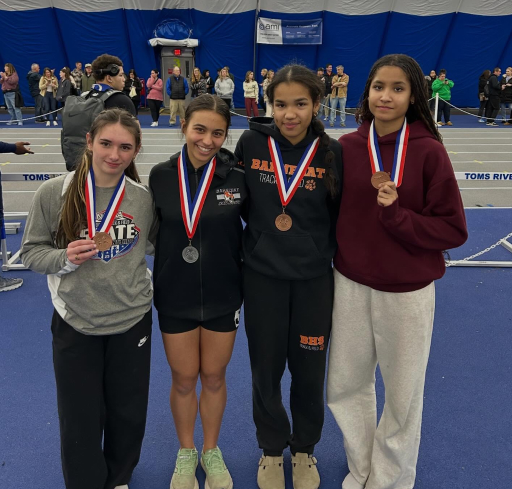 Image of Angelina, Raegan, Kiyana, and Amaya posing with their medals around their necks. 