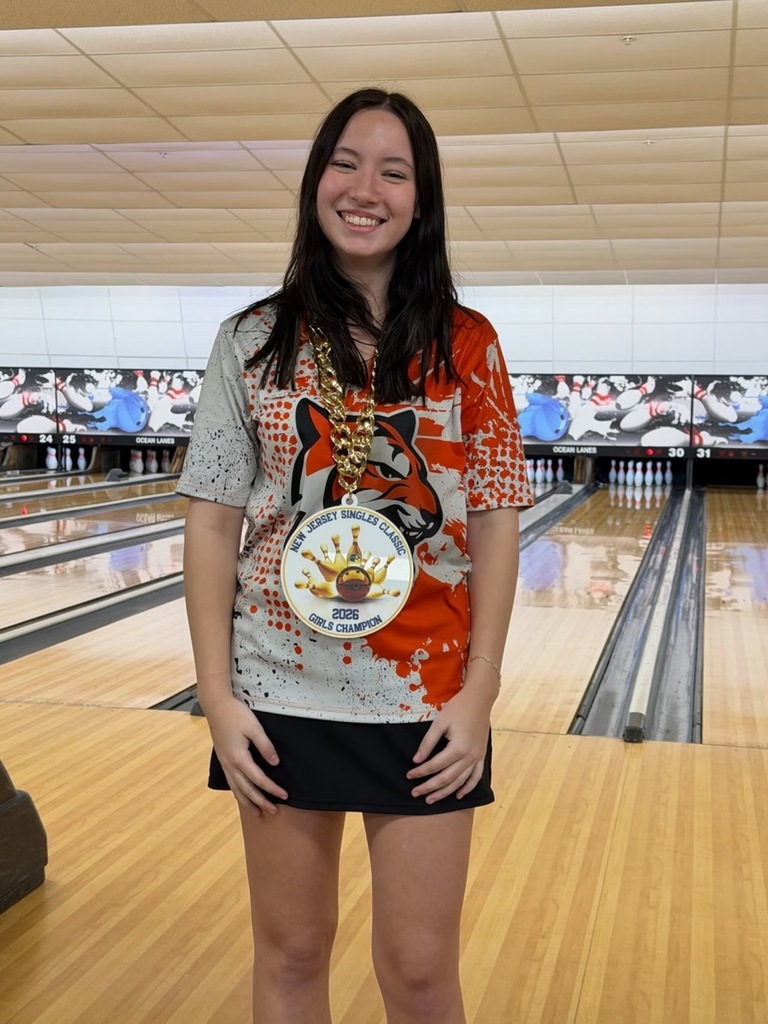 Image of Jamie White wearing a large medal around her neck. 