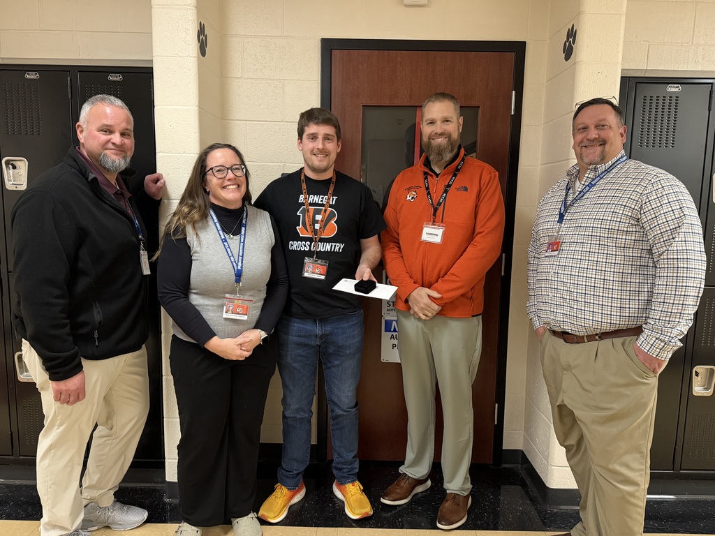 Image of James posing with the Superintendent and building administrators. 