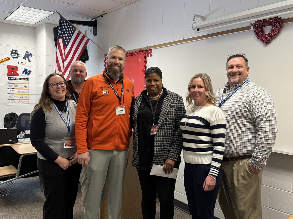 Image of Sajdah posing with the Superintendent and building administrators. 