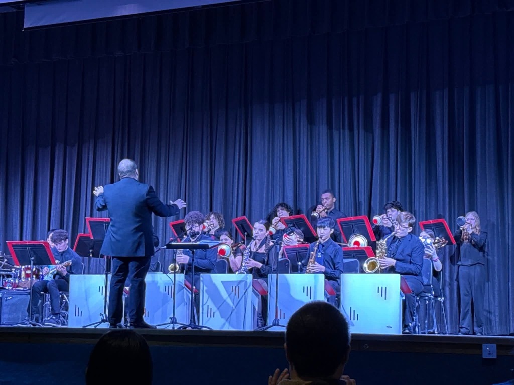 Image of the jazz band playing on stage with Mr. McGrath conducting. 