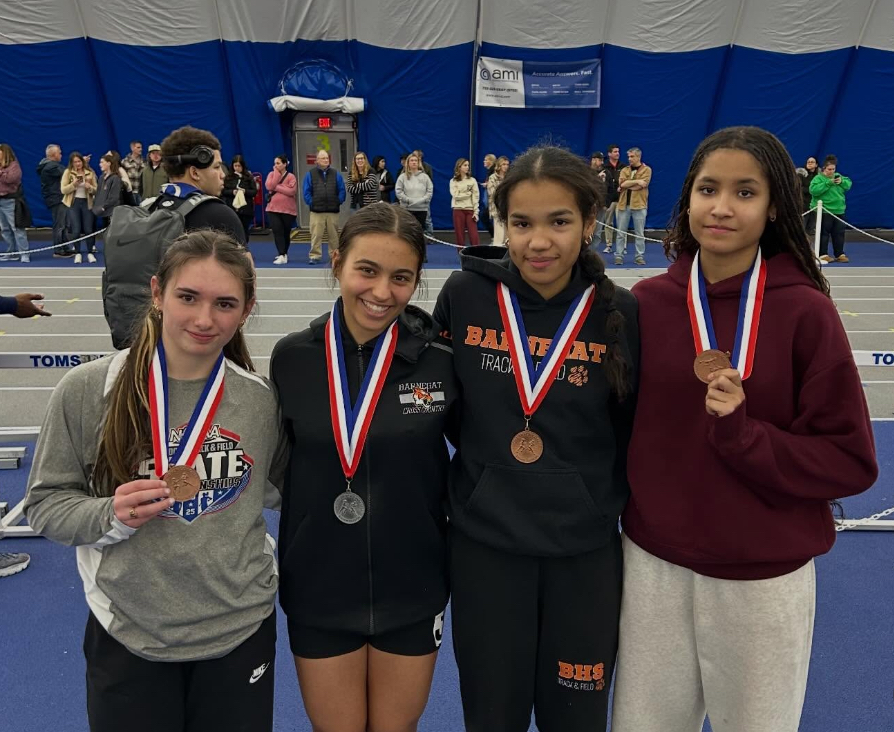 Image of Raegan, Angelina, Kiyana, and Amaya posing with their arms around one another wearing their medals around their necks.