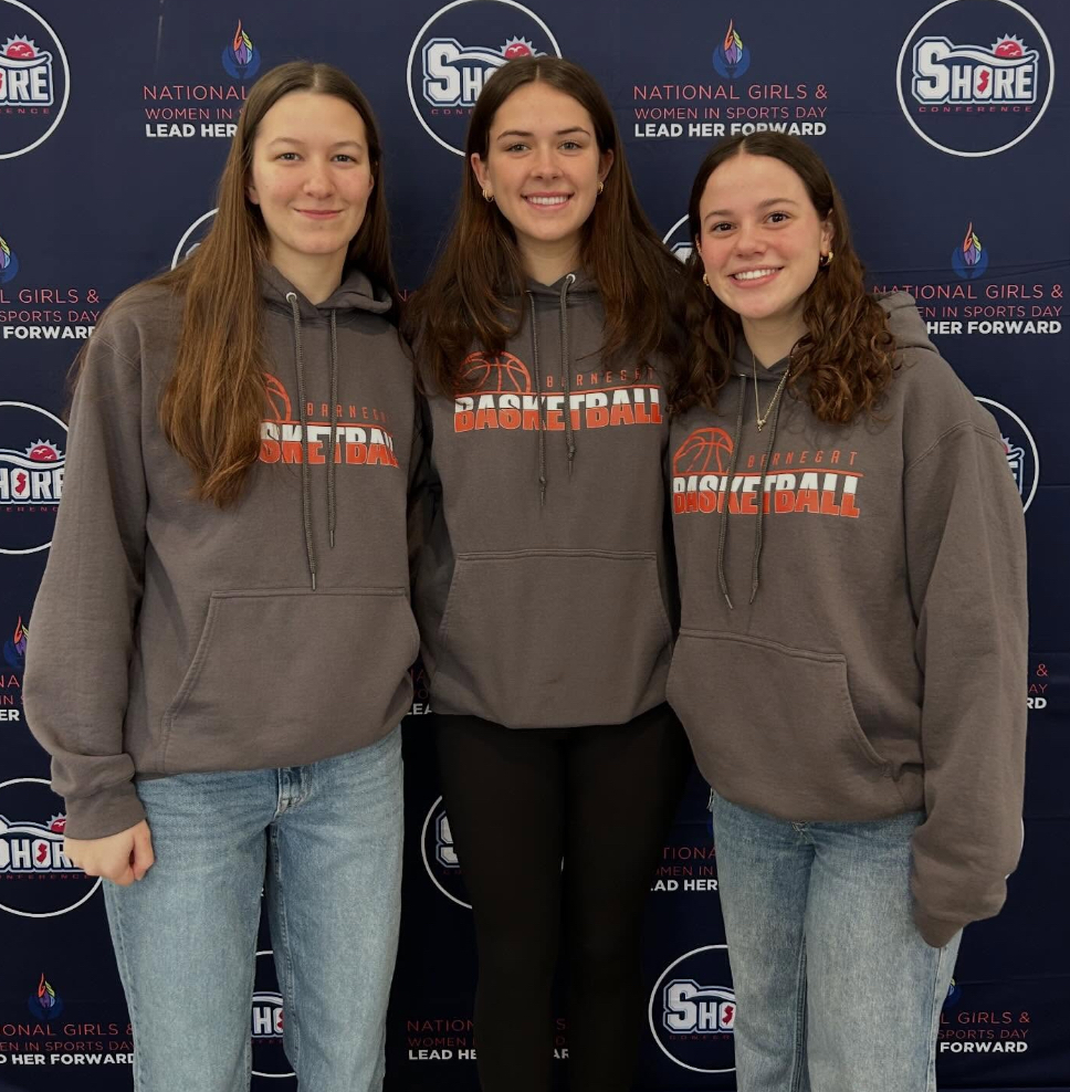 Image of the three girls posing with their arms around one another in front of the Shore Conference banner.
