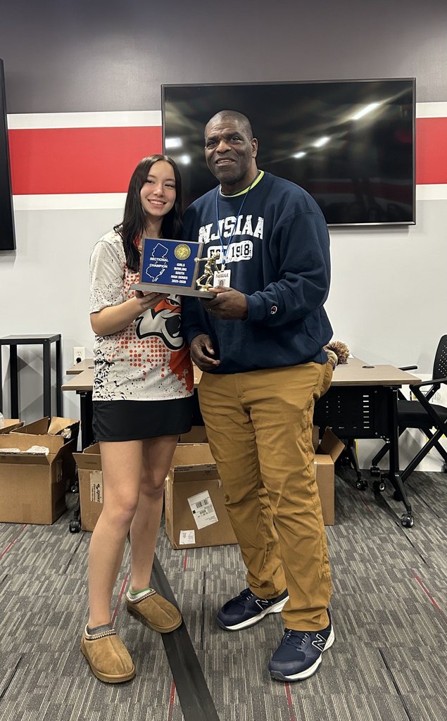 Jamie posing with an NJSIAA official holding her Sectional Champion High Series plaque.