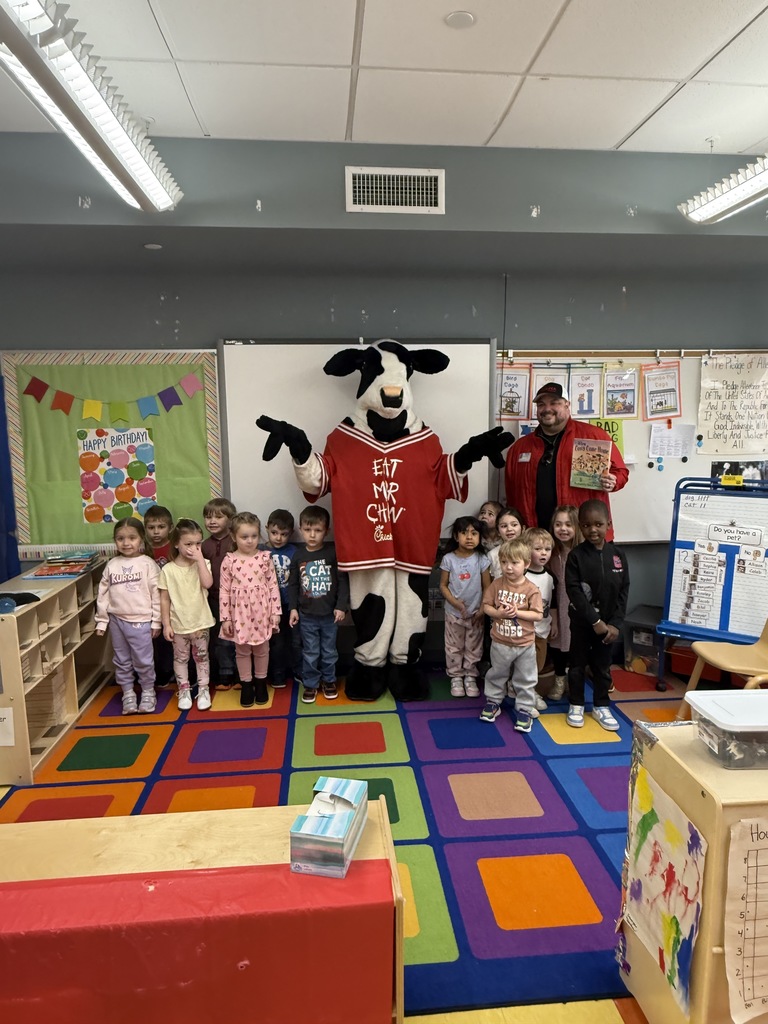 Image of a class posing with the owner of Chick-Fil-A and the mascot Milkshake. 
