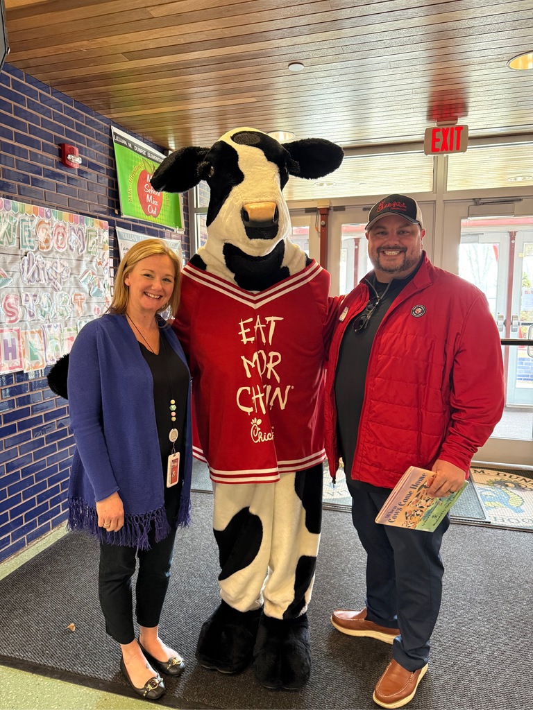 Image of the Principal posing with the owner of Chick-Fil-A and the mascot Milkshake. 