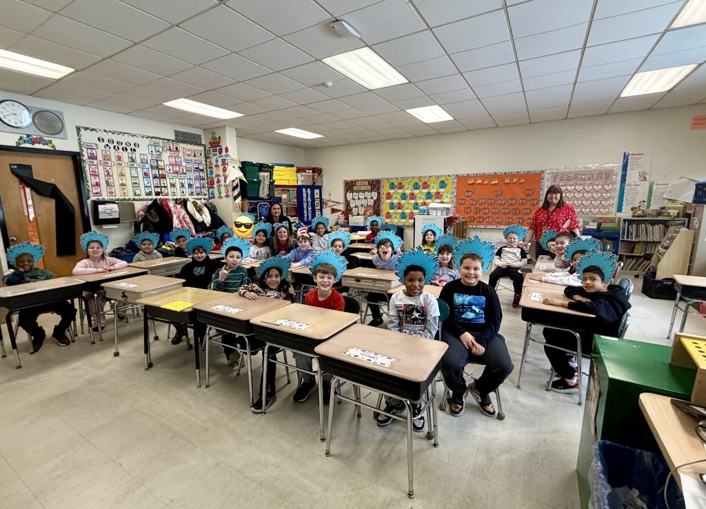 Image of Ms. McGlynn and her class posing in Thing 1 hats with the curriculum secretaries who read to the class. 