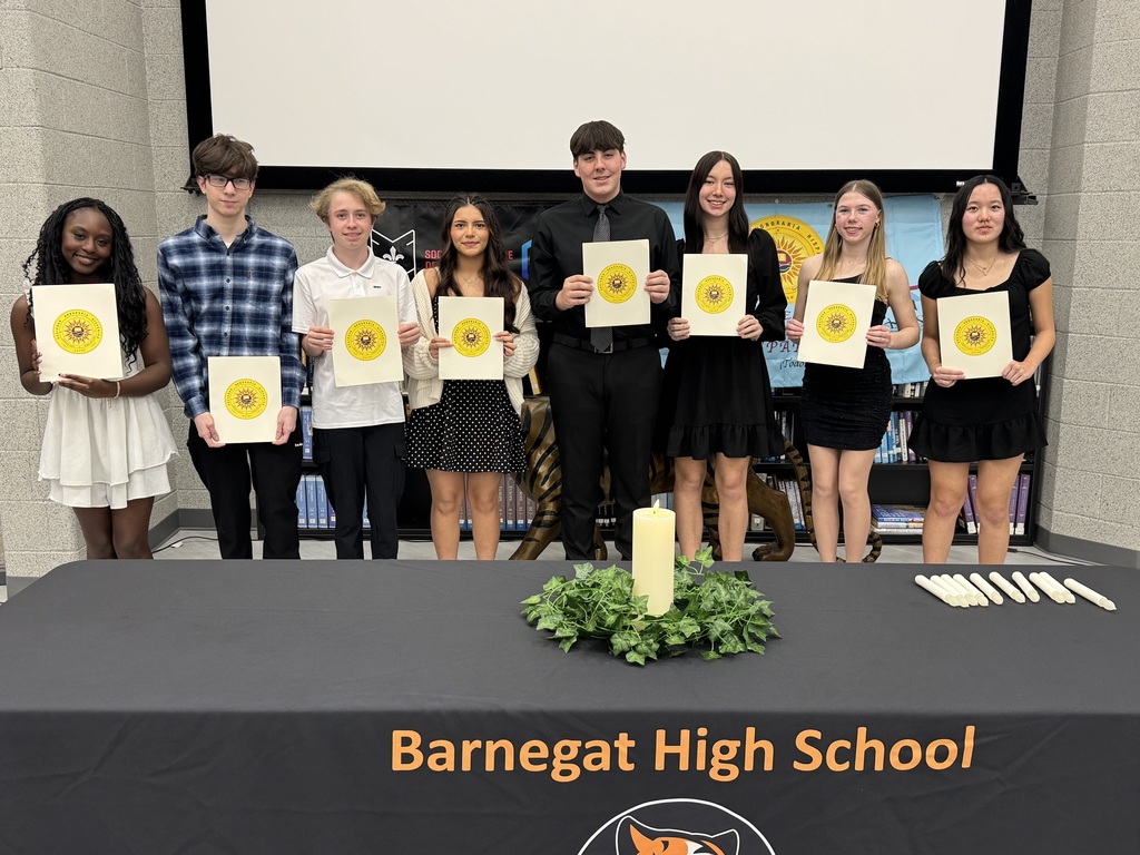 Image of the eight students holding their certificates behind a table with candles. 