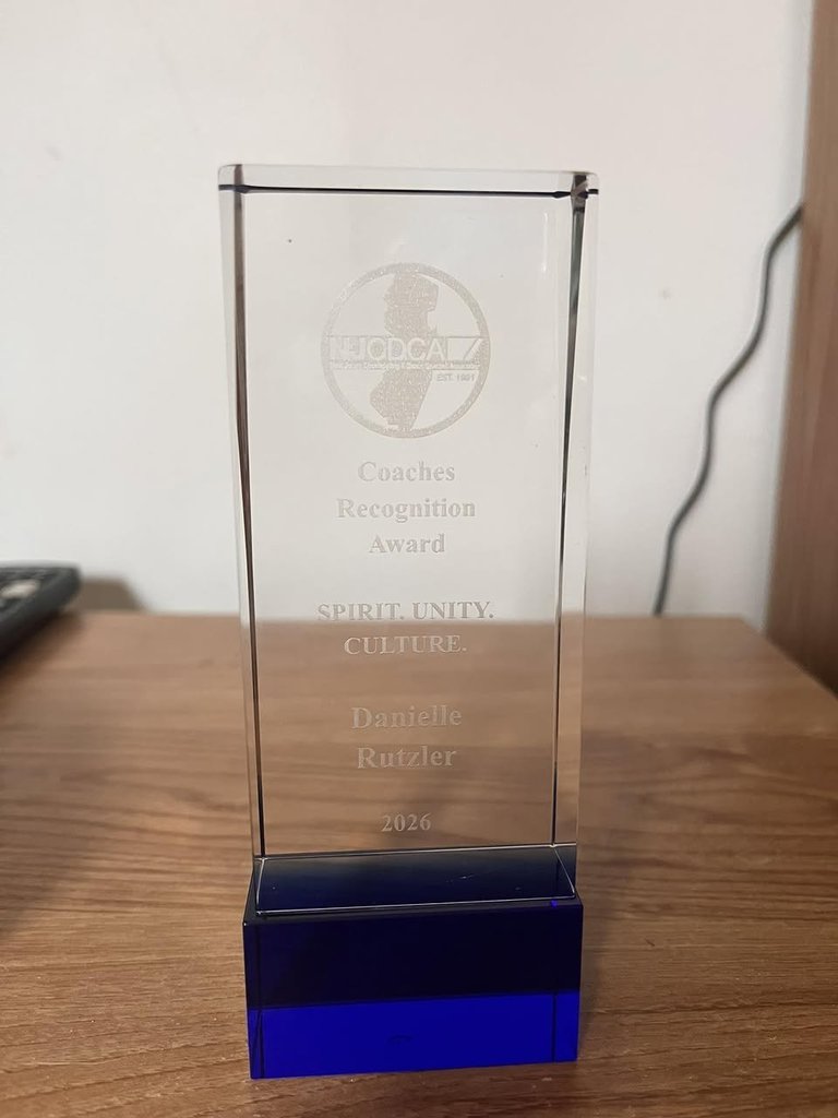 Image of the Coaches Recognition Award displayed on a table. 