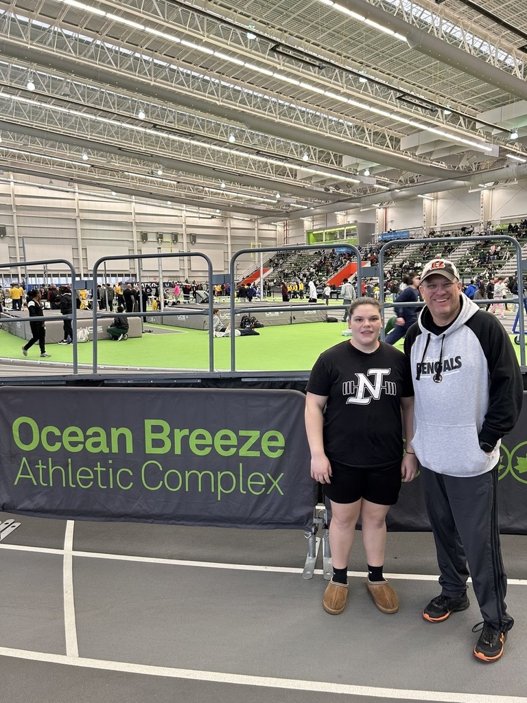 Image of Ellie posing with her coach on the indoor track. 