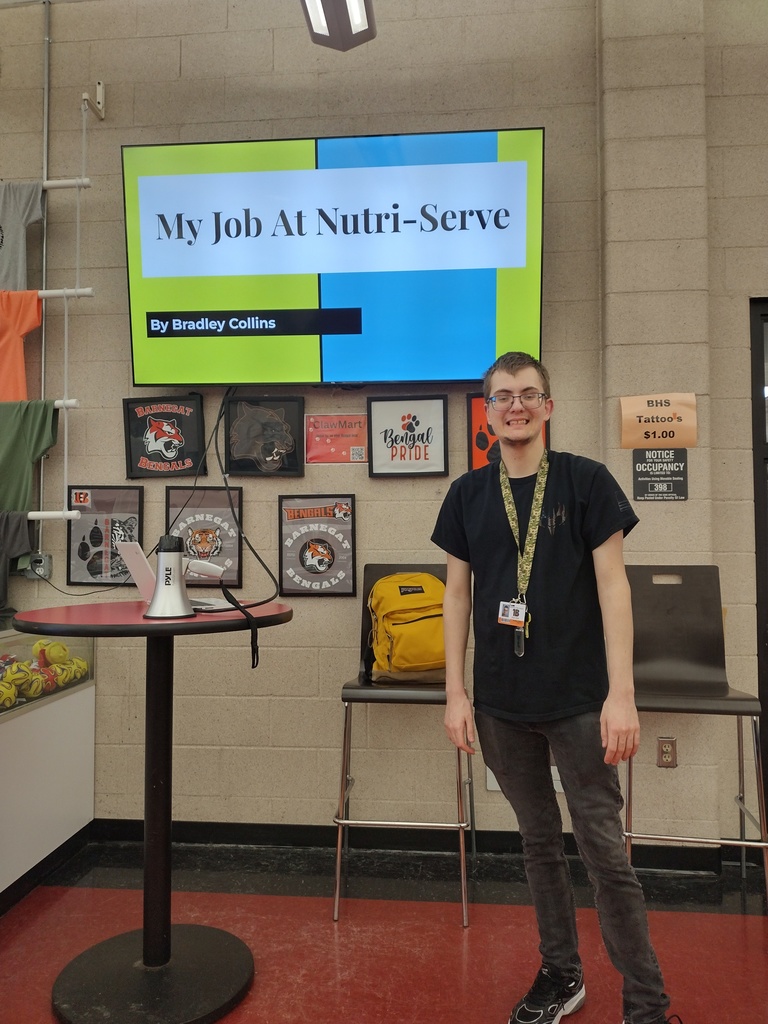 Image of a male student posing in front of his powerpoint about his job with Nutri-Serve. 