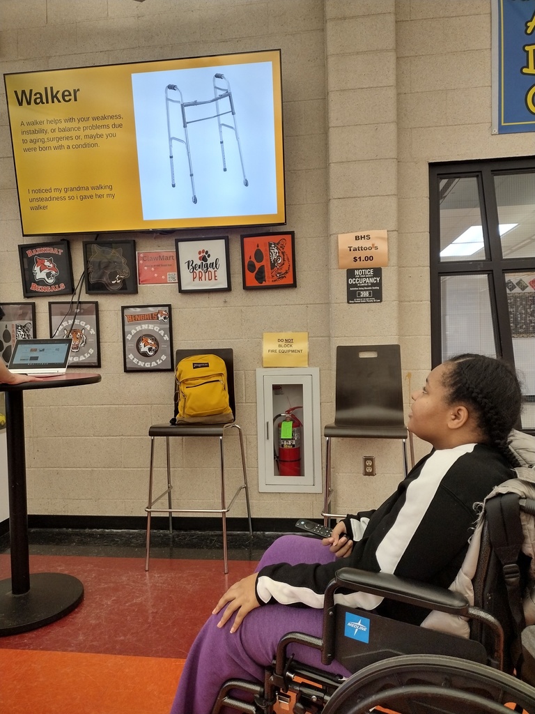 Image of a female student in a wheelchair presenting about using a walker for a workplace modification. 